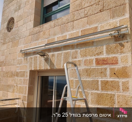 סולם ליד קיר אבן עם מסילה מותקנת